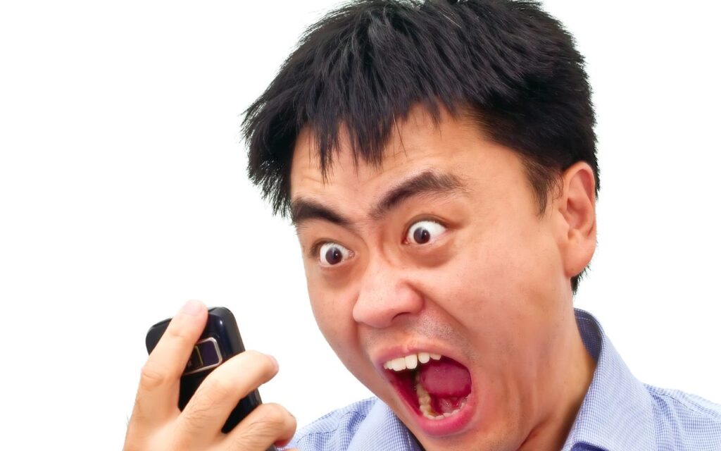 _angry asian man yelling at phone