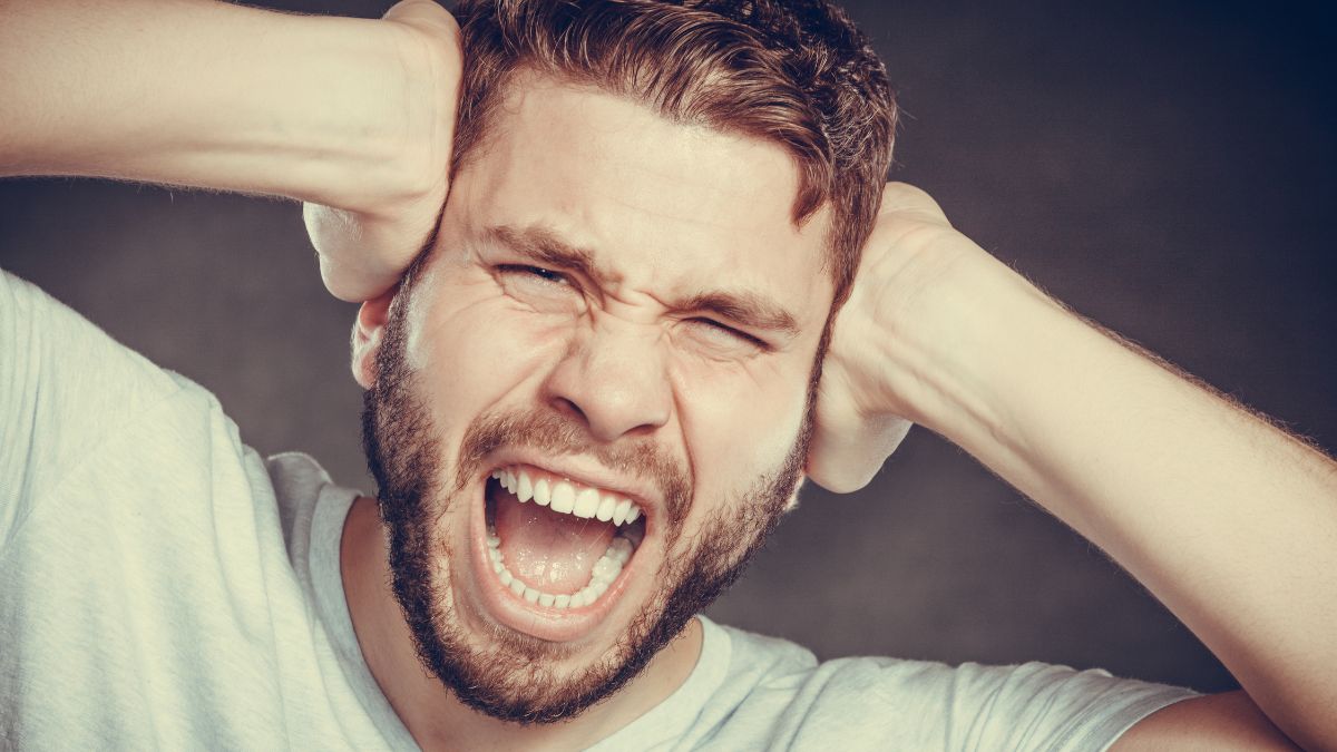 angry man holding his head screaming