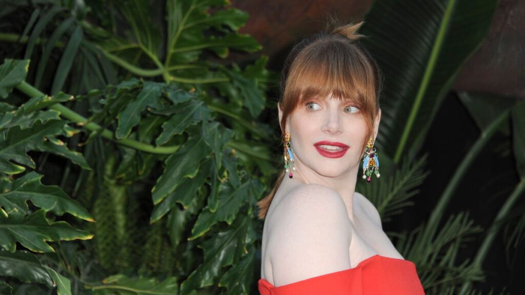 bryce dallas howard in a red dress looking over her shoulder