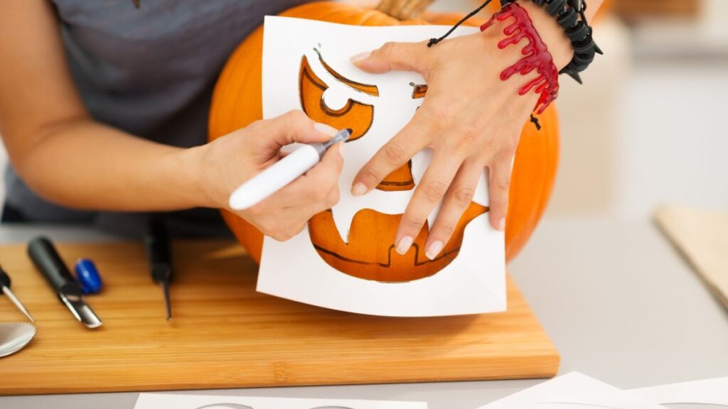 Carve Jack-O-Lanterns person carving a pumpkin