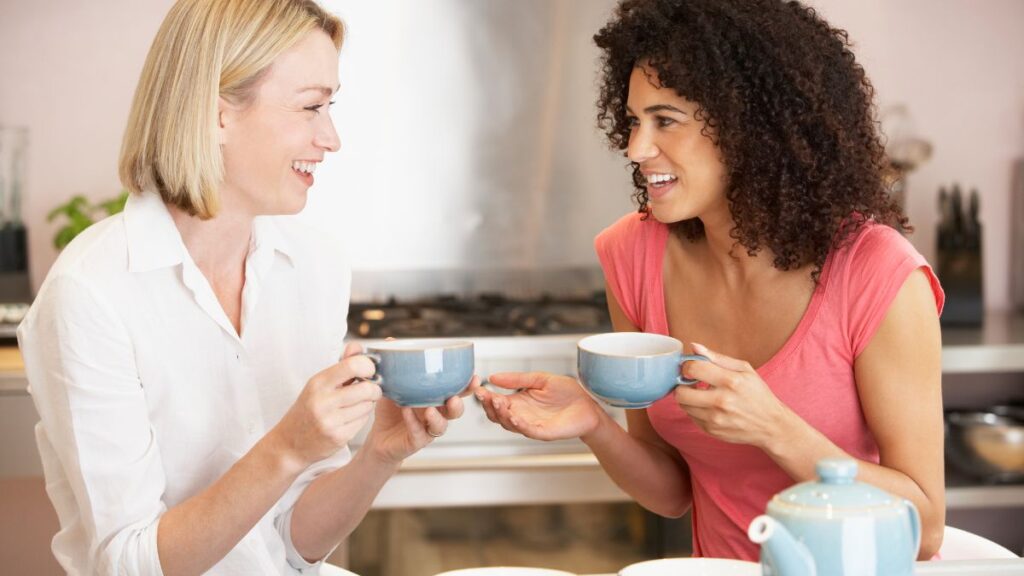 Communication two women sitting and talking with teacups