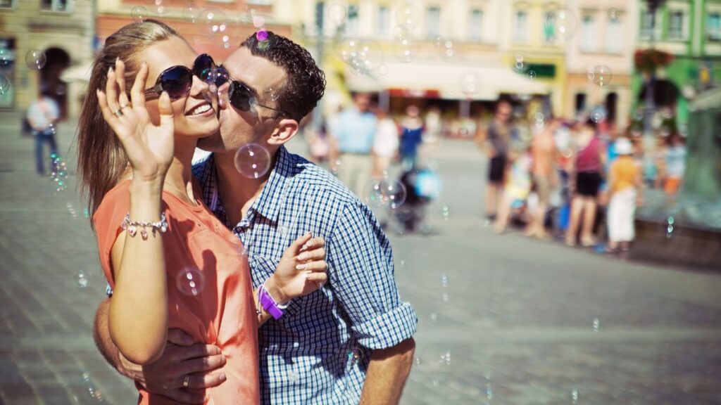 couple hugging and kissing outside with bubbles