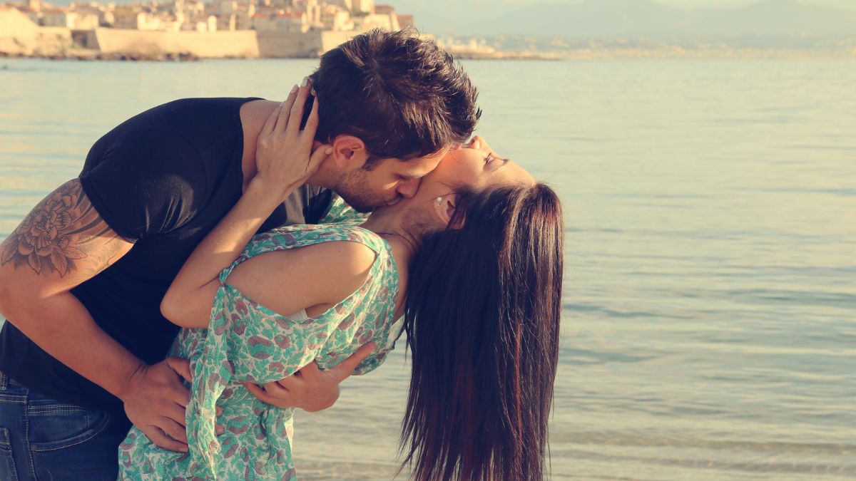 couple kissing by the water