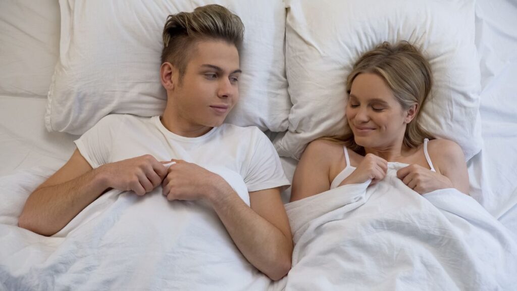 couple laying in bed smiling and happy