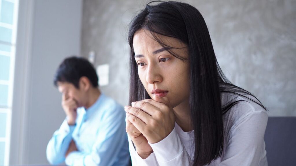 couple, sad woman man behind her sad too