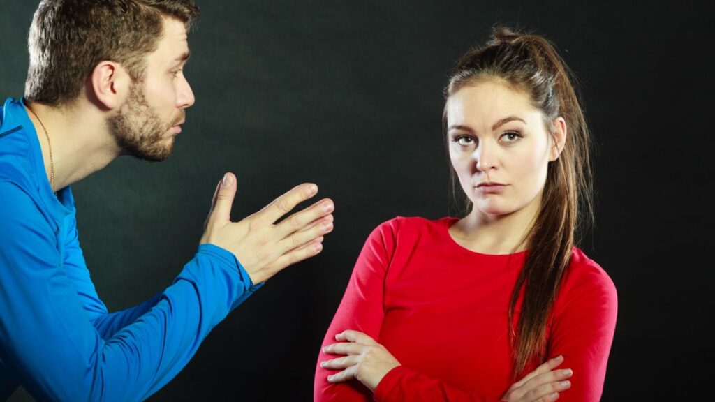 couple upset man talking and woman looking irritated with arms crossed