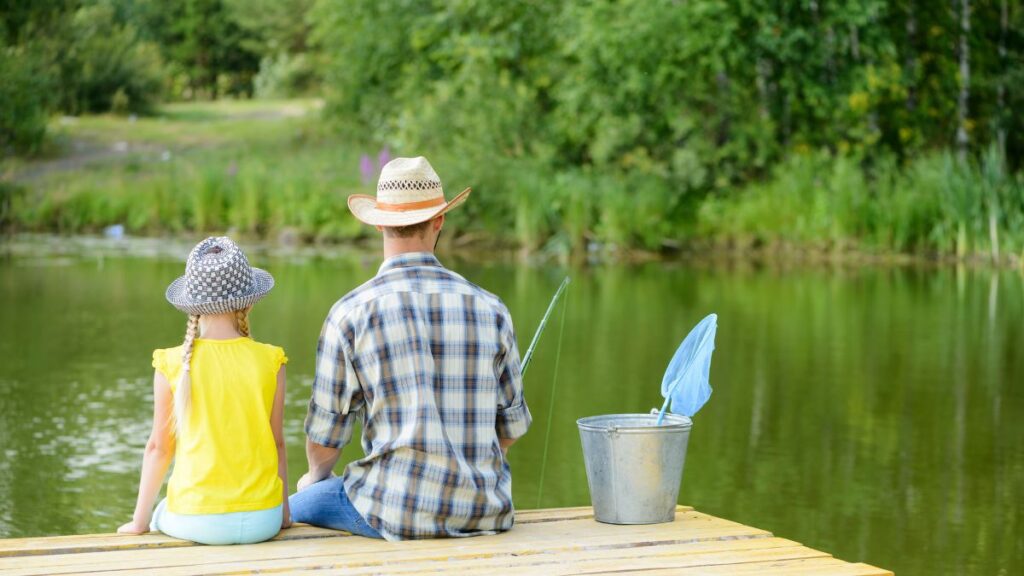 Dad and Daughter Fishing off a pier seeing their backs only