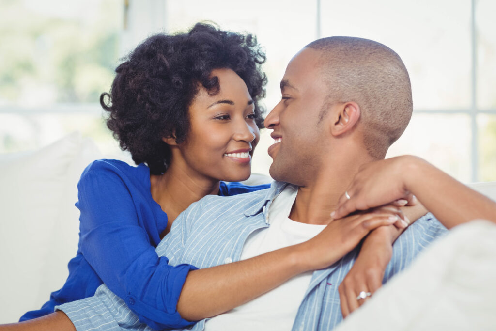 smiling couple on the sofa looking at each other