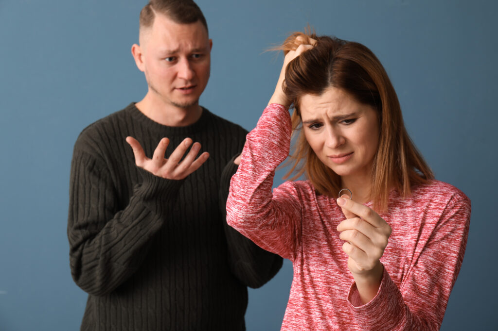 man and woman looking unhappy, woman holding a ring