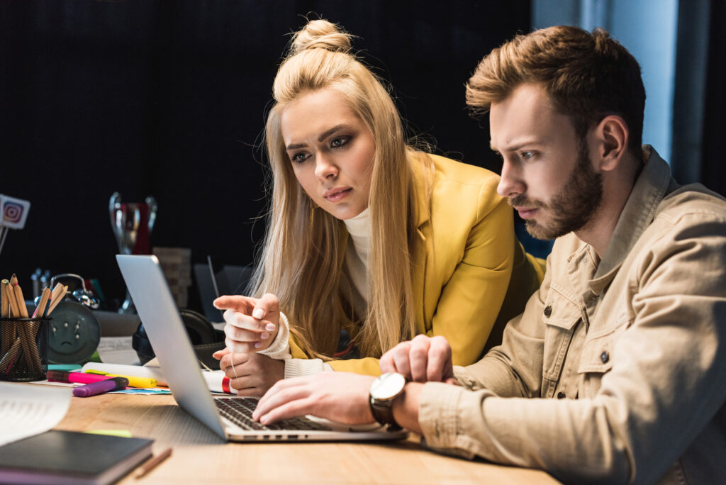 woman looking at a computer screen with her husband