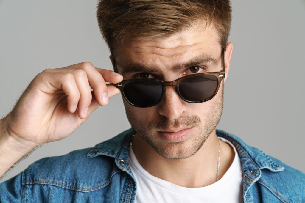 Portrait of confident man in sunglasses posing and looking at camera