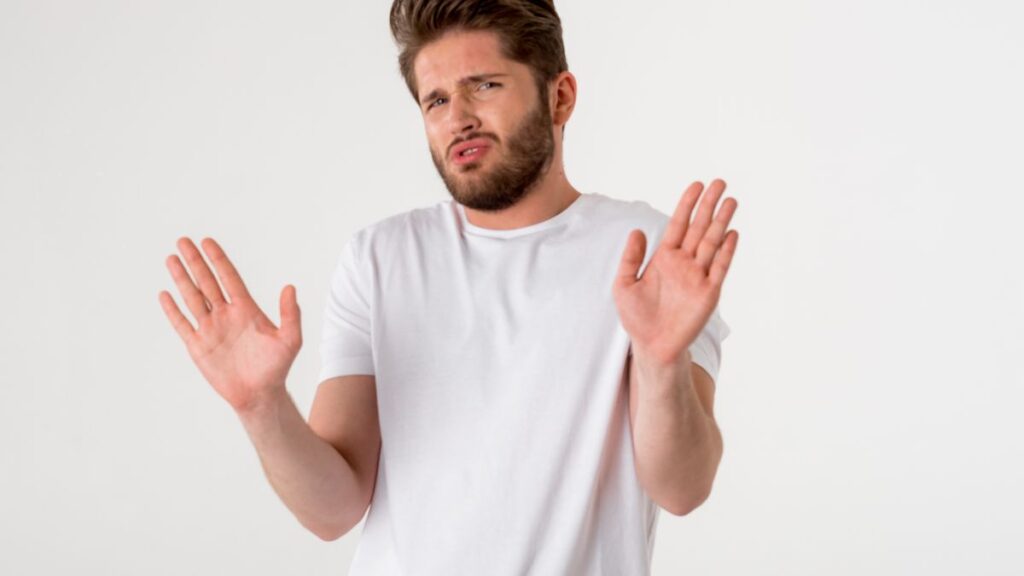 disgusted man with his hands up in a white shirt