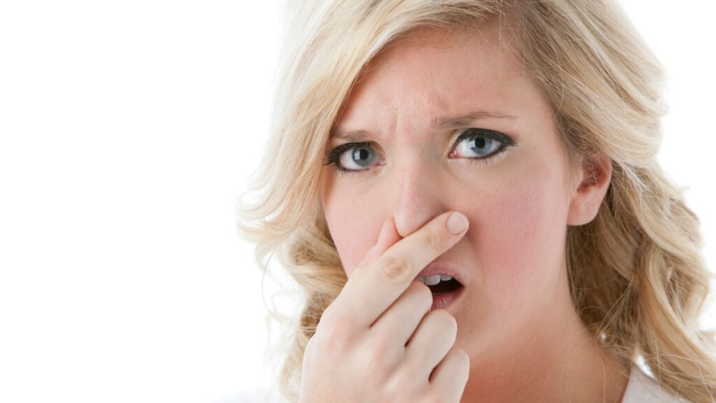 disgusted woman holding her nose