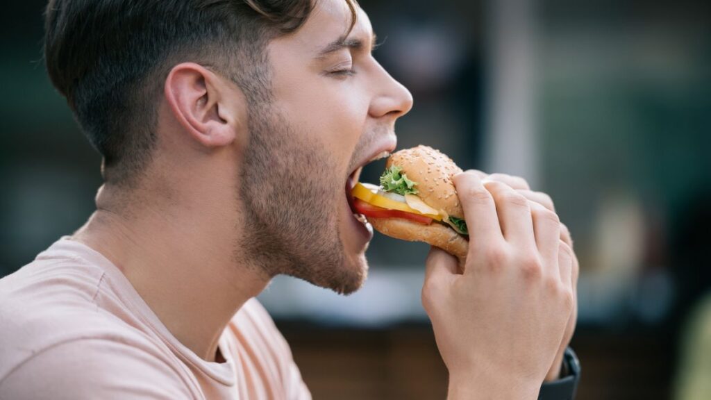 Man eating a sandwich. Side view