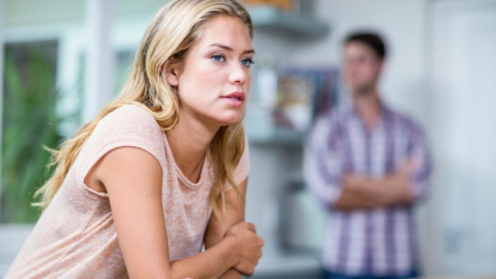 Emotionally Distant man and woman staring away from each other looking dissatisfied.