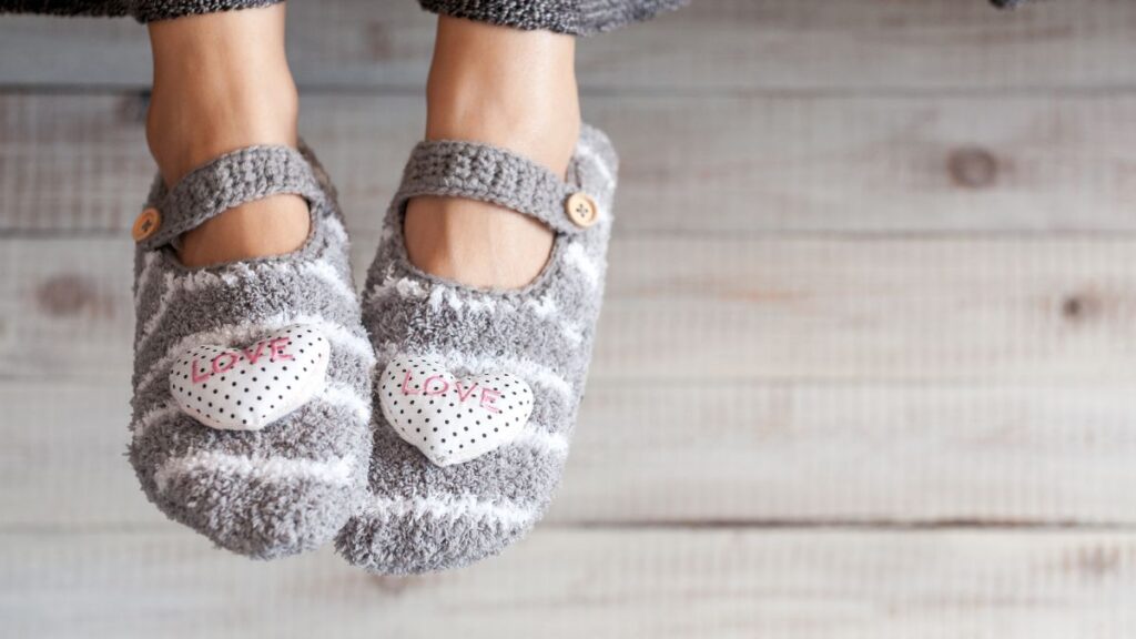 Feet with cute grey slippers on