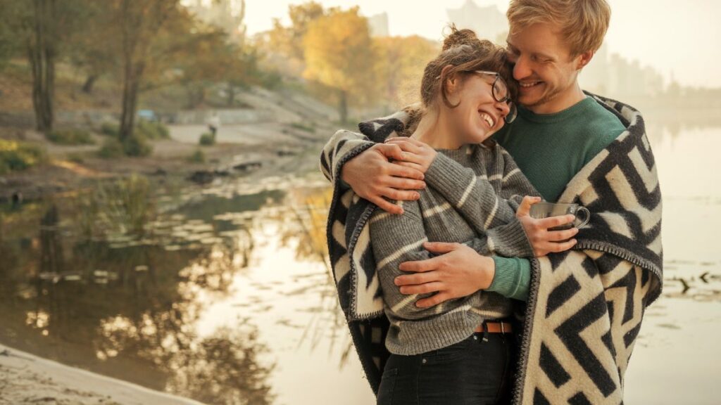 happy couple hugging by the water