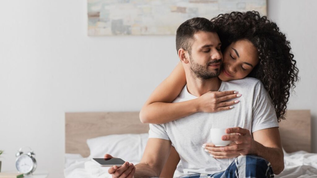 happy couple snuggling on the bed