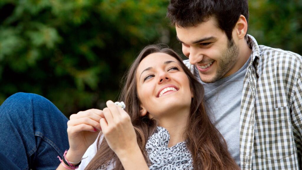 happy couple snuggling outside and smiling at each other