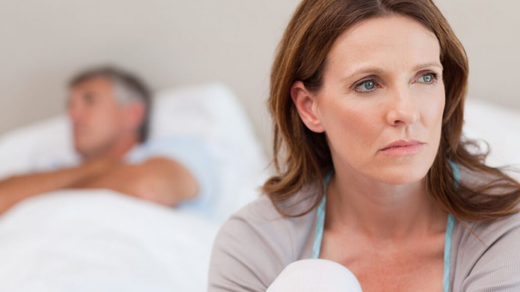 woman and man looking upset away from each other and man in bed