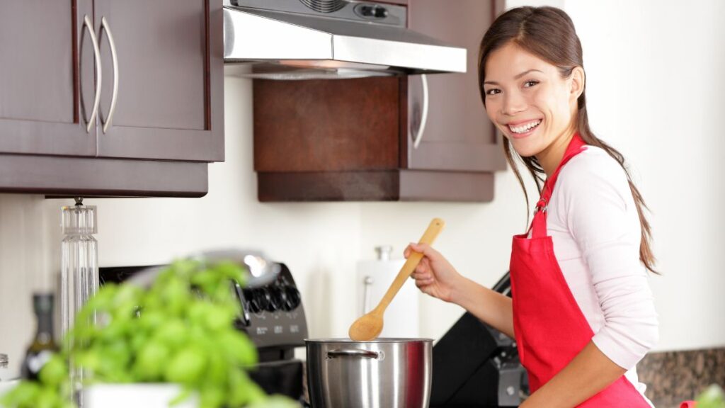 Homemade Food woman cooking at the stove in a red apron