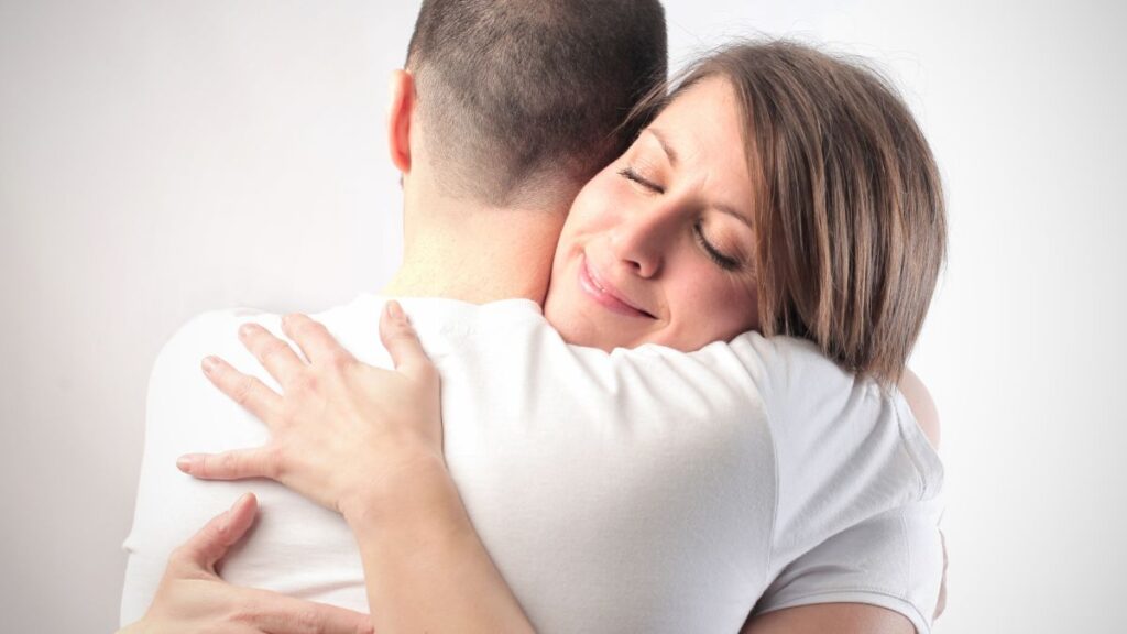 Hug: man and woman hugging man looking away