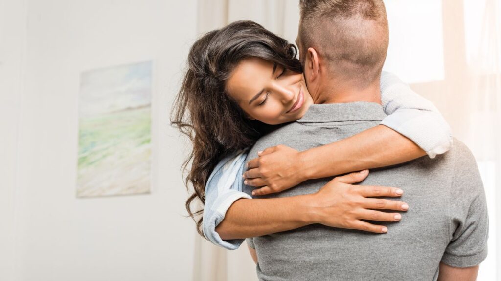 Hugs: man and woman hugging woman smiling.