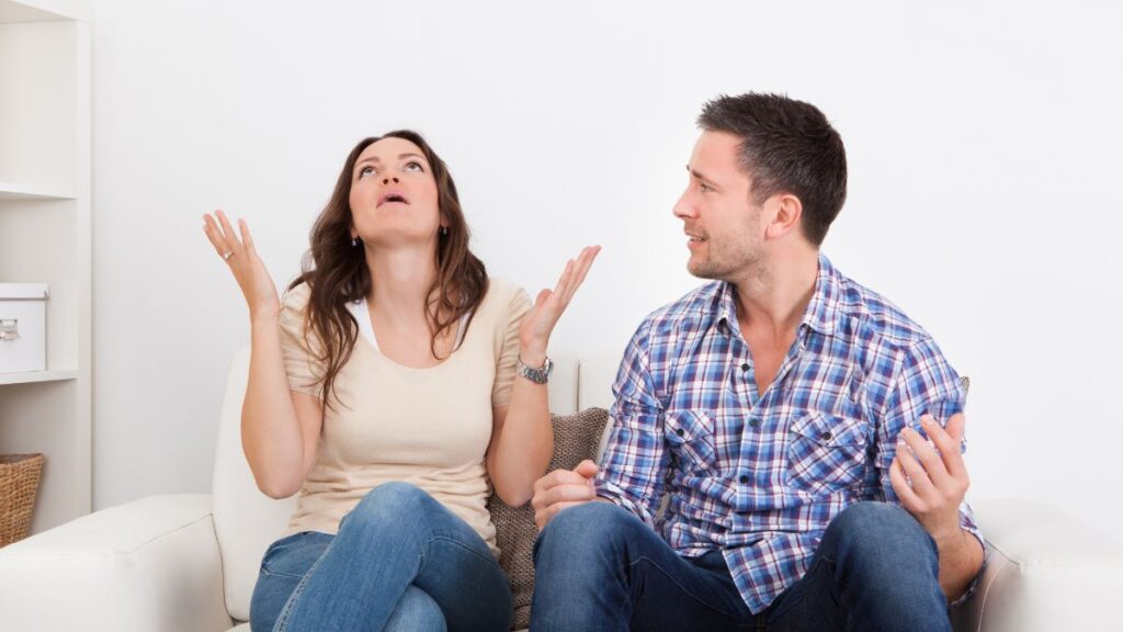 irritated couple fighting on the couch