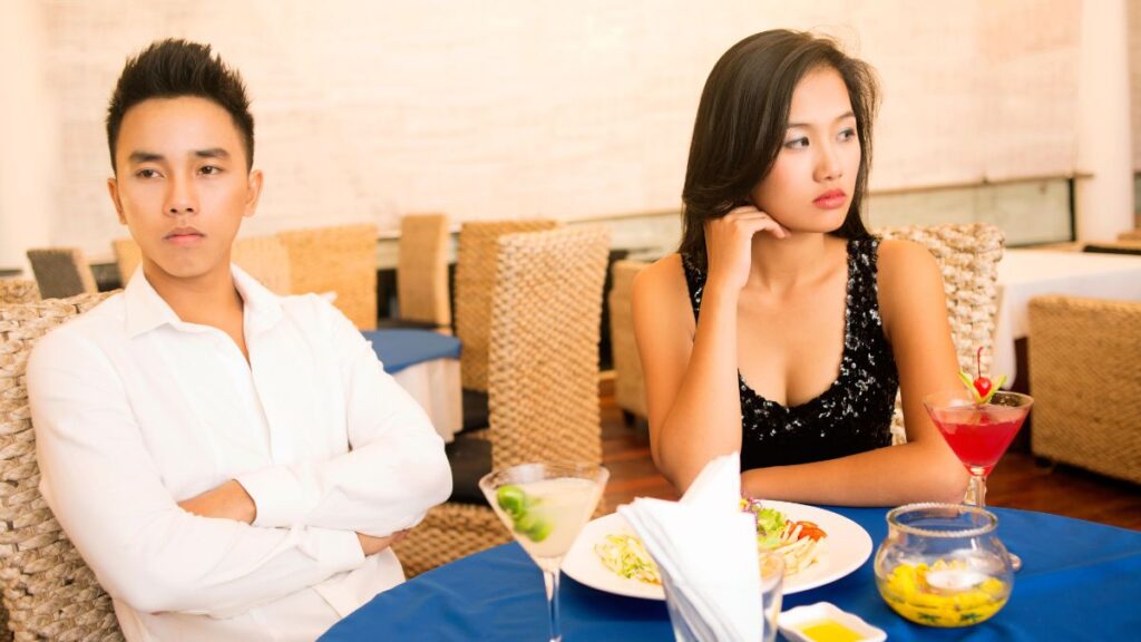 irritated couple looking away from each other at dinner