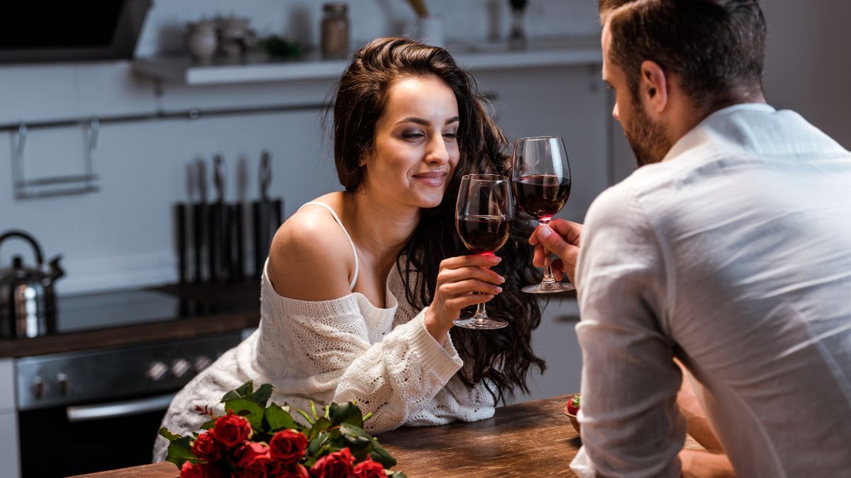 Love couple doing cheers with wine and flowers