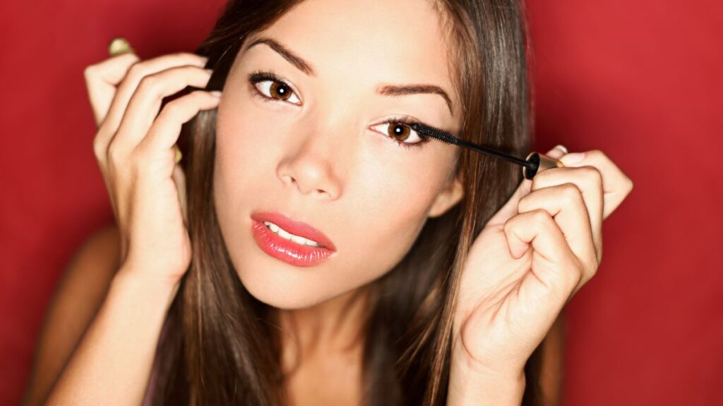 Makeup application techniques woman putting on mascara