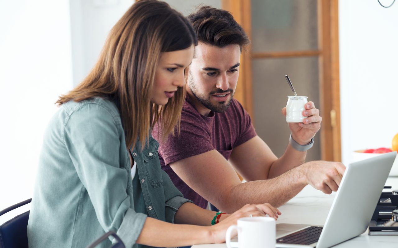 man and woman at the computer helping eachother