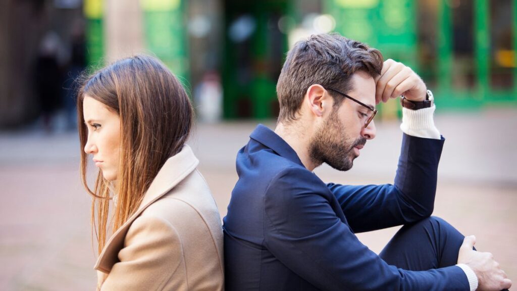 Man and Woman back to back looking upset