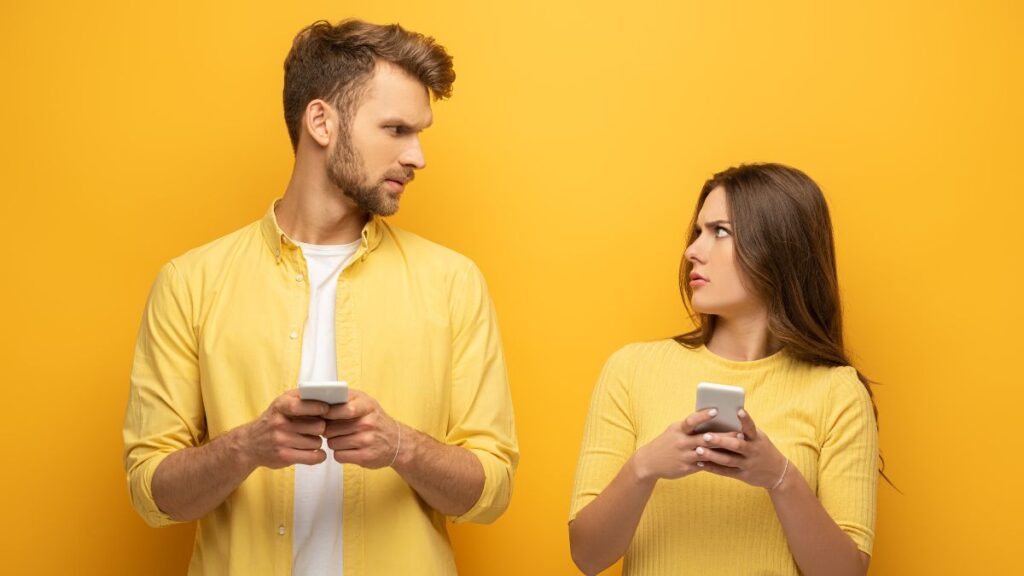 man and woman looking confused at one another. Yellow background.