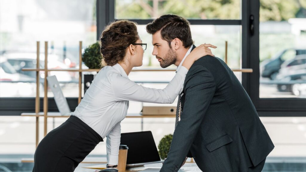 Woman and man leaning over a table at work getting close.