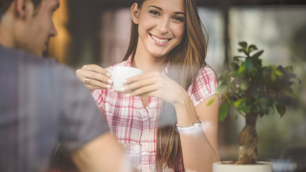 man and woman sitting with coffee on a first date