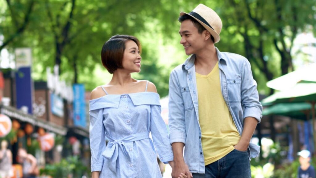 Man and woman walking in the park holding hands 