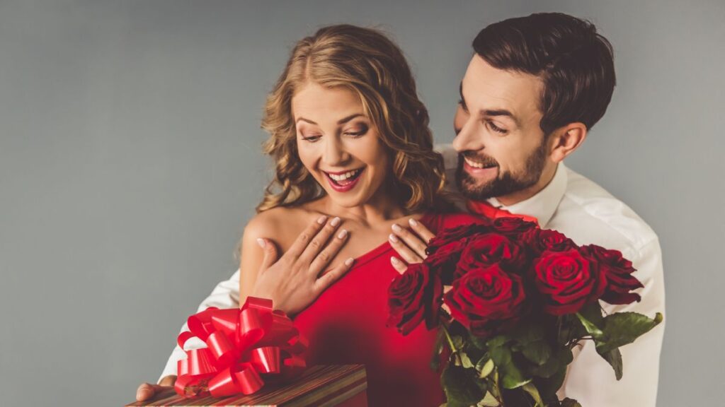 Man gifting a woman with flowers and a gift