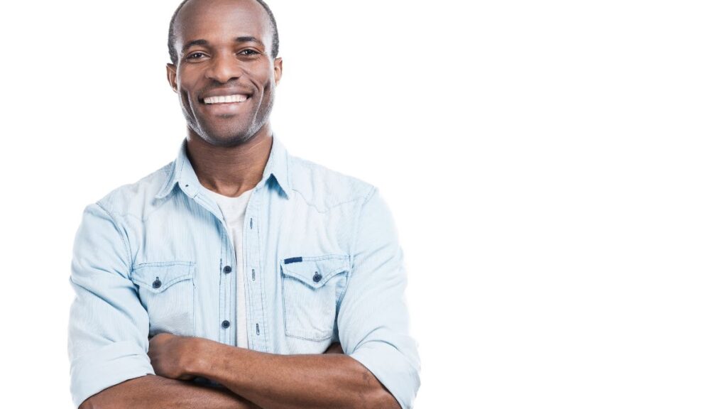 man in a blue shirt smiling with his arms crossed