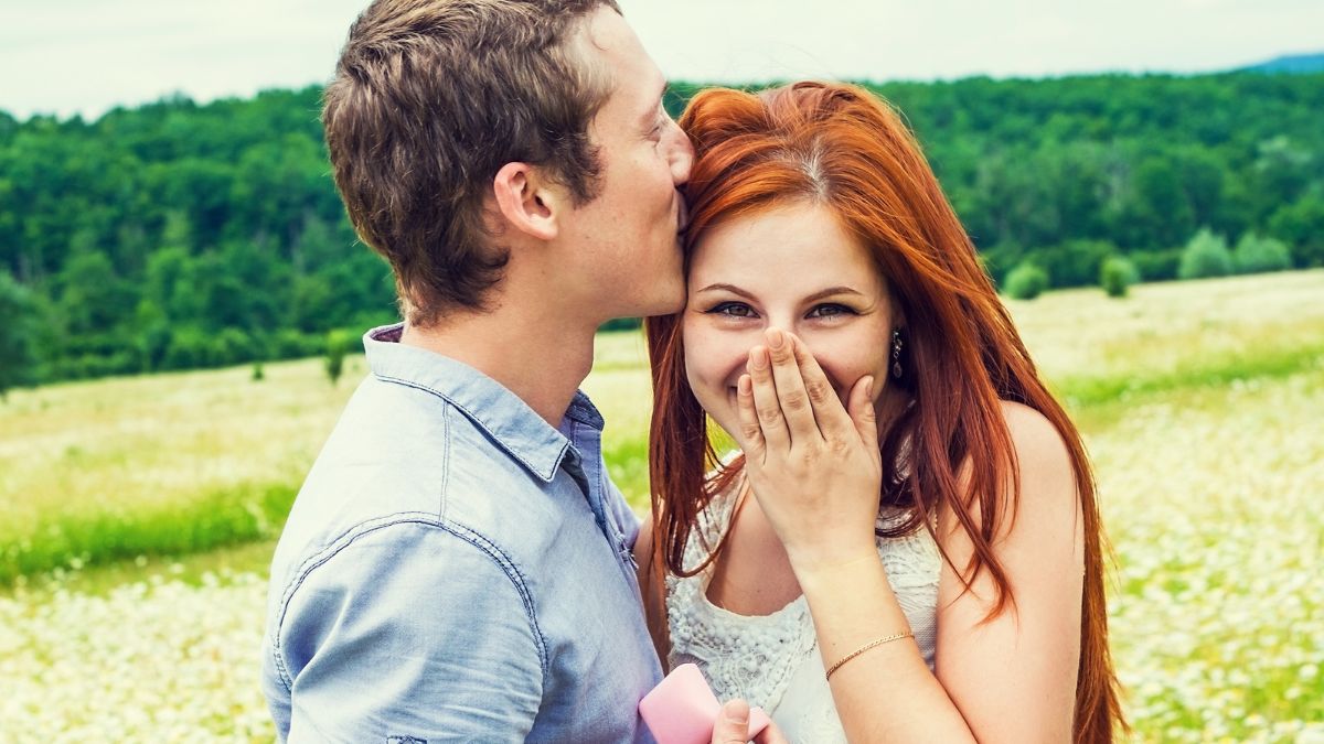 _Man kissing a woman's head. Woman looking happy