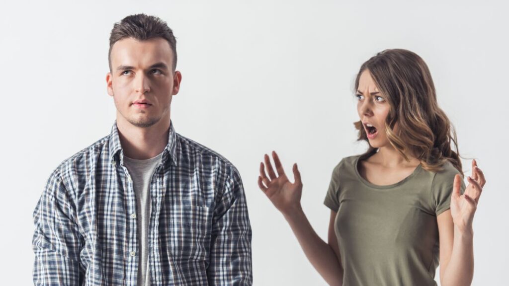 Man looking annoyed, eye rolling woman looking shocked at him