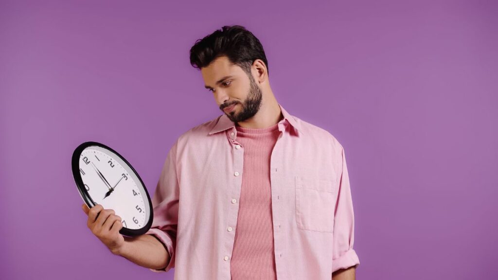 man looking at clock annoyed