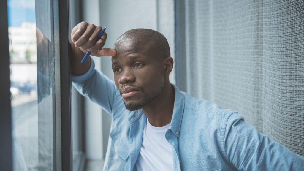 man looking pensive out the window