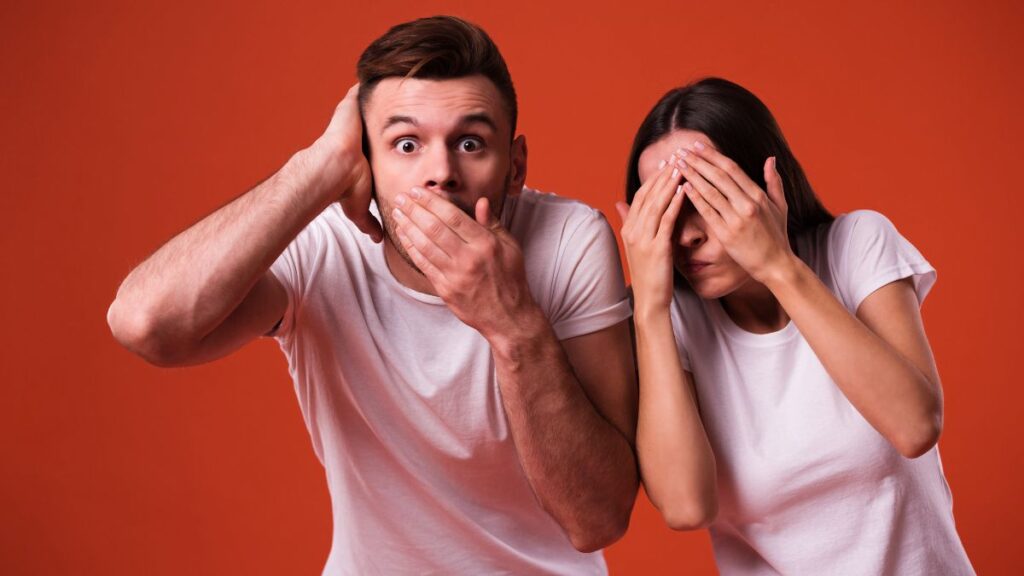 Man looking shocked covering his mouth and woman hiding her face with her hands