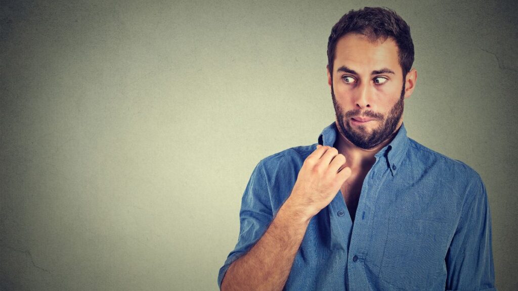 man looking uncomfortable pulling his collar