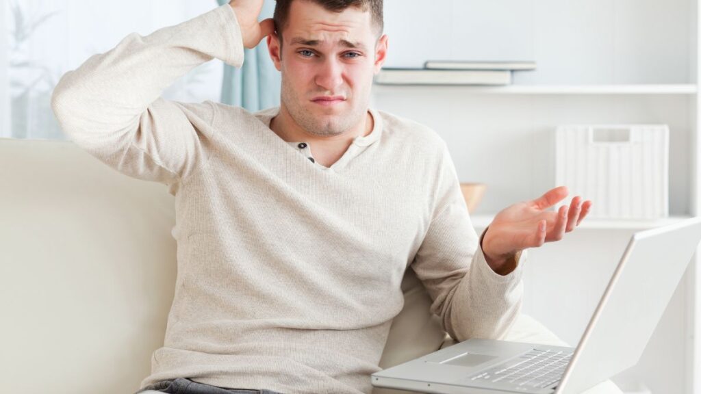 man sitting at the computer looking confused