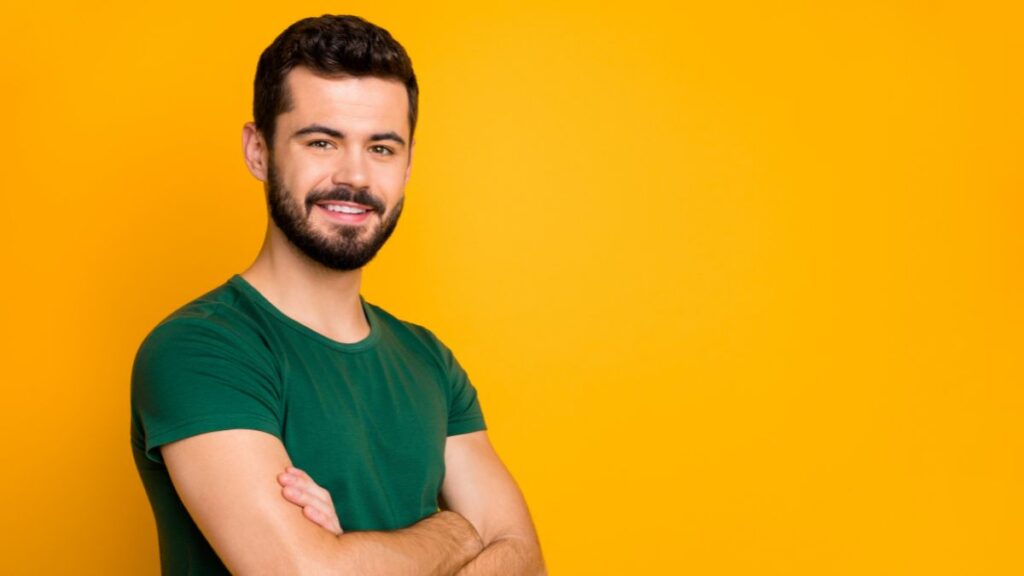 man smiling with arms crossed