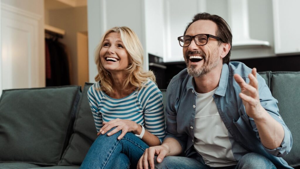 Naturally Funny couple sitting and laughing