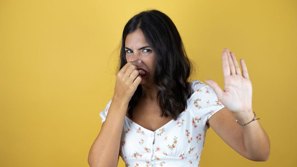 Beautiful woman over yellow background smelling something stinky - Image credits Depositphotos SpaceImages.