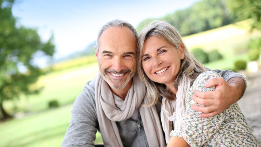 older couple sitting outside and smiling